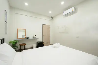 a white bedroom with a large bed and a desk at XX Hidden Dragon Yaowarat Road in Bangkok