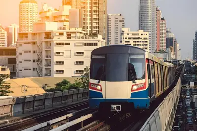 a train is on the tracks in a city at I LOVE BANGKOK - Thai Style Room near Skytrain Asok, T21, and EM District Malls in Bangkok