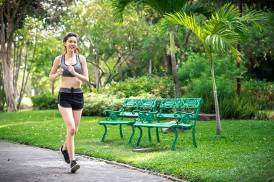 a woman walking down a sidewalk in a park at I LOVE BANGKOK - Thai Style Room near Skytrain Asok, T21, and EM District Malls in Bangkok