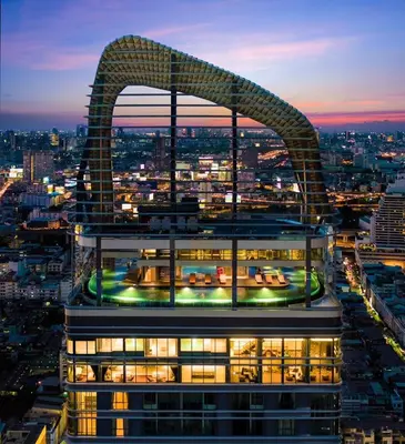 a building with a sculpture on top of it at night at 1 Bedroom at Q Chidlom in Bangkok