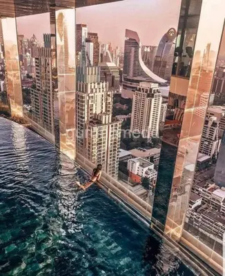 a person swimming in a pool in a city at 1 Bedroom at Q Chidlom in Bangkok