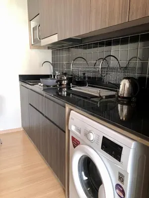 a kitchen with a washing machine in a kitchen at Resort style family room near BTS Bearing in Ban Khlong Samrong