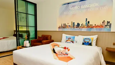 a hotel room with a bed with a poster on the wall at Metro Hotel Phahonyothin 35 in Bangkok