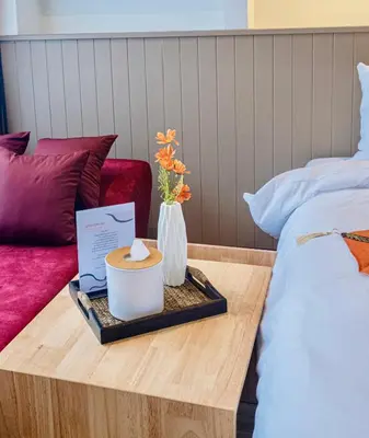 a tray with a candle and flowers on a bed at Metro Hotel Phahonyothin 35 in Bangkok