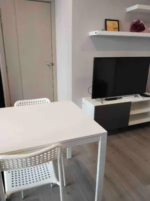 a living room with a white table and a tv at Great facilities n River view n Local in Ban Sai Ma