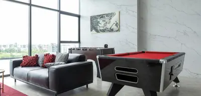 a living room with a couch and a pool table at The Rich Rama 9 Luxury Condos in Sathani Ban Hua Mak
