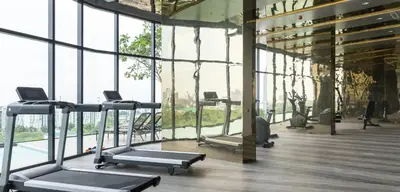 a gym with several treadmills in a room with windows at The Rich Rama 9 Luxury Condos in Sathani Ban Hua Mak