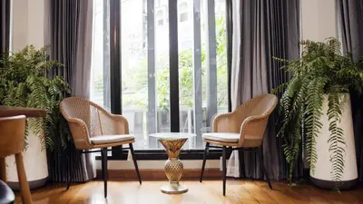 two chairs and a table in front of a window at Poshtel 56 in Bangkok