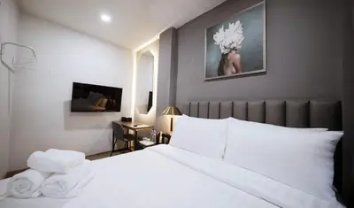 a bedroom with a large white bed with white pillows at Poshtel 56 in Bangkok