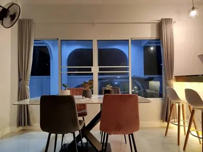 a dining room with a table and chairs and a window at Hidden Gems Residence in Ban Sala Daeng