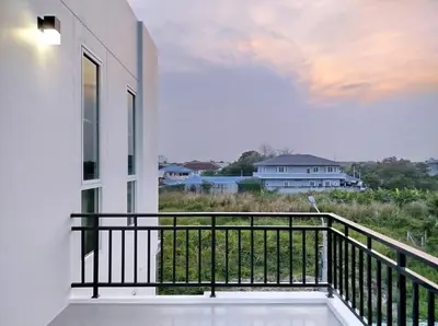 a balcony with a view of a house at Hidden Gems Residence in Ban Sala Daeng
