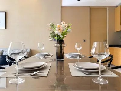 a dining room table with glasses and a vase of flowers at Saladaeng Residences at Silom in Bangkok