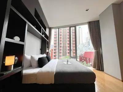 a bedroom with a large bed and a large window at Saladaeng Residences at Silom in Bangkok