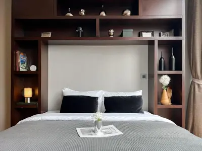 a bedroom with a large bed with wooden shelves at Saladaeng Residences at Silom in Bangkok