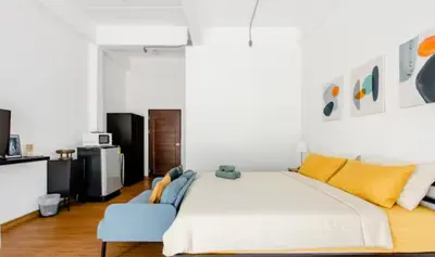 a bedroom with a large bed and a blue chair at Homemade Ice cream house in local village in Bangkok