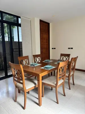 a dining room with a wooden table and chairs at Central BKK Luxuxy Pool Villa 4BR in Bangkok