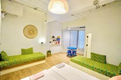a room with two green couches and a table at Old Town Heritage Lofts Bangkok in Bangkok