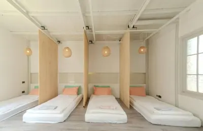 a room with three beds in it with a window at Old Town Heritage Lofts Bangkok in Bangkok