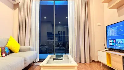 a living room with a couch and a large window at Artisan Ratchada Huge 1BR Condos in Bangkok