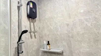 a bathroom with a shower with a phone on the wall at Artisan Ratchada Huge 1BR Condos in Bangkok