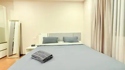 a bedroom with a large bed with a mirror at Artisan Ratchada Huge 1BR Condos in Bangkok