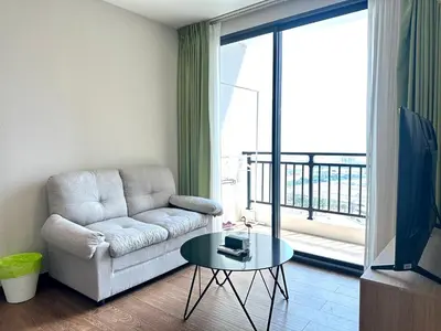 a living room with a couch and a glass table at Artisan Ratchada Huge 1BR Condos in Bangkok