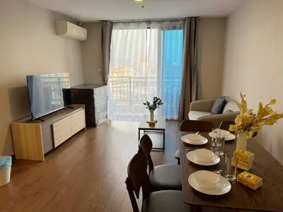 a living room with a table and a couch and a television at Artisan Ratchada Spacious 2BR Condos in Bangkok