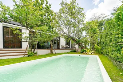 a swimming pool in the yard of a house at The Lodge Bangkok Poolvilla in Sathani Khlong Tan