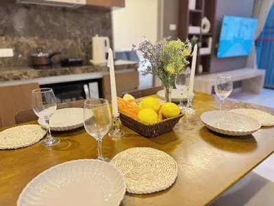 a table with plates and glasses and a bowl of fruit at 2 Bed 2 Bath Phrom Phong BTS in Bangkok