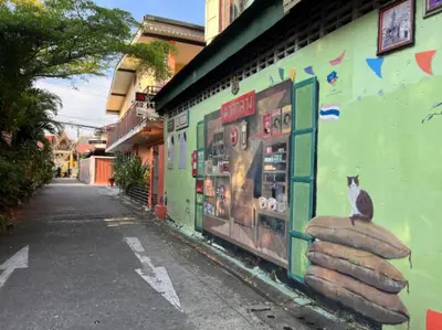 a building with a cat on the side of it at Tiny Cozy Room - Wat Arun in Bangkok
