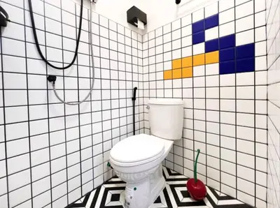 a bathroom with a white toilet in a tiled wall at Tiny Cozy Room - Wat Arun in Bangkok