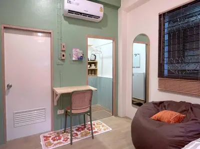a room with a couch and a desk and a chair at Tiny Cozy Room - Wat Arun in Bangkok