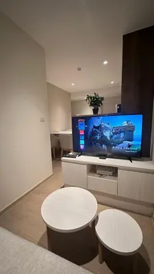 a living room with two tables and a flat screen tv at Paradise condo-perfect location in Bangkok