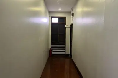 a hallway with a black door and a window at Orchid Hostel Near Bumrungrad hospital and Nana Market in Bangkok