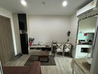 a living room with a table and a kitchen at Nich Mono Ramkhumheng Low Rise in Sathani Ban Hua Mak