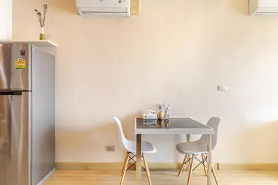 a kitchen with a table and two chairs and a refrigerator at Super City View Room, Swimming Pool,Gym,150m walk to BTS in Bangkok