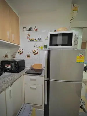 a kitchen with a microwave on top of a refrigerator at Condo with Pool View & Great Amenities Bangkok in Sathani Ban Hua Mak