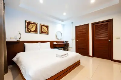 a bedroom with a large white bed and a desk at XX YON INN - Sukhumvit 4 BTS NANA in Bangkok