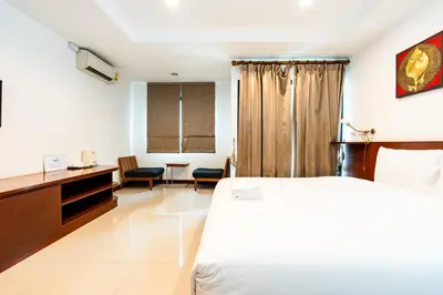 a bedroom with a bed and a desk and chairs at XX YON INN - Sukhumvit 4 BTS NANA in Bangkok