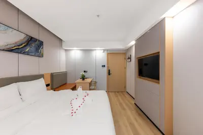 a bedroom with a large bed and a flat screen tv at Rama9 No1 Hotel in Bangkok