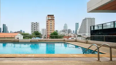 a swimming pool on top of a building with a city skyline at King Bed, Park, BTS 5min | Free Parking, Fast WiFi in Khlong Toei