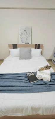 a bed with a book and towels on it at New room DMKairport,BTS, impact 340 in Ban Song Hong