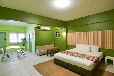 a bedroom with green walls and a bed and a desk at XX GO INN The Grand Palace - โกอินน์ พระบรมมหาราชวัง MRT สามยอด in Bangkok