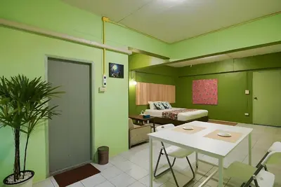 a room with green walls and a table and a bed at XX GO INN The Grand Palace - โกอินน์ พระบรมมหาราชวัง MRT สามยอด in Bangkok