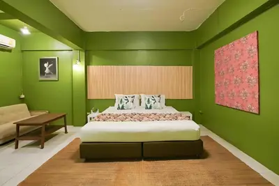 a green bedroom with a bed and a desk at XX GO INN The Grand Palace - โกอินน์ พระบรมมหาราชวัง MRT สามยอด in Bangkok