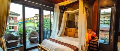 a bedroom with a canopy bed and a balcony at Garden and pool Villa bangkok in Bang O