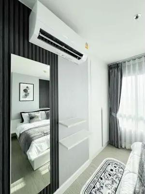a white bedroom with a bed and a mirror at Prime Near Sathorn Sukhumvit Central in Chong Nonsi