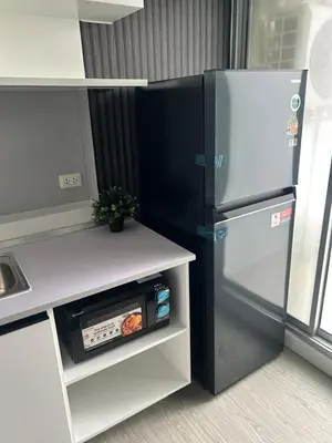 a refrigerator in a kitchen next to a counter at Prime Near Sathorn Sukhumvit Central in Chong Nonsi