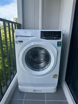 a washing machine is sitting on a balcony at Brand new Condo near ICON SIAM in Bangkok