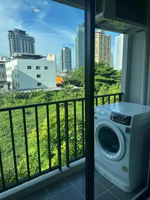 a washing machine on a balcony with a view of a city at Brand new Condo near ICON SIAM in Bangkok
